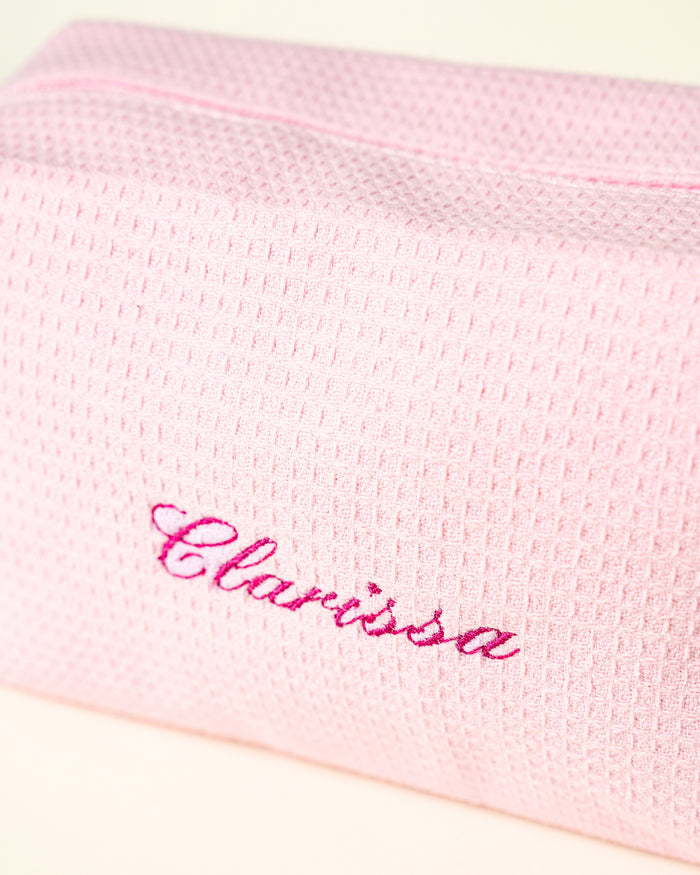 A pink waffle pouch embroidered with the name Clarissa